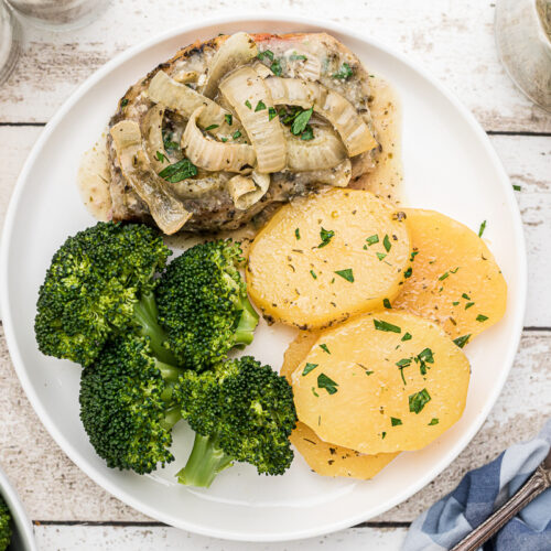 overhead shot of pork chops and potatoes on plate.