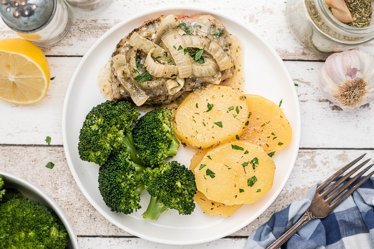 overhead shot of pork chops and potatoes on plate.