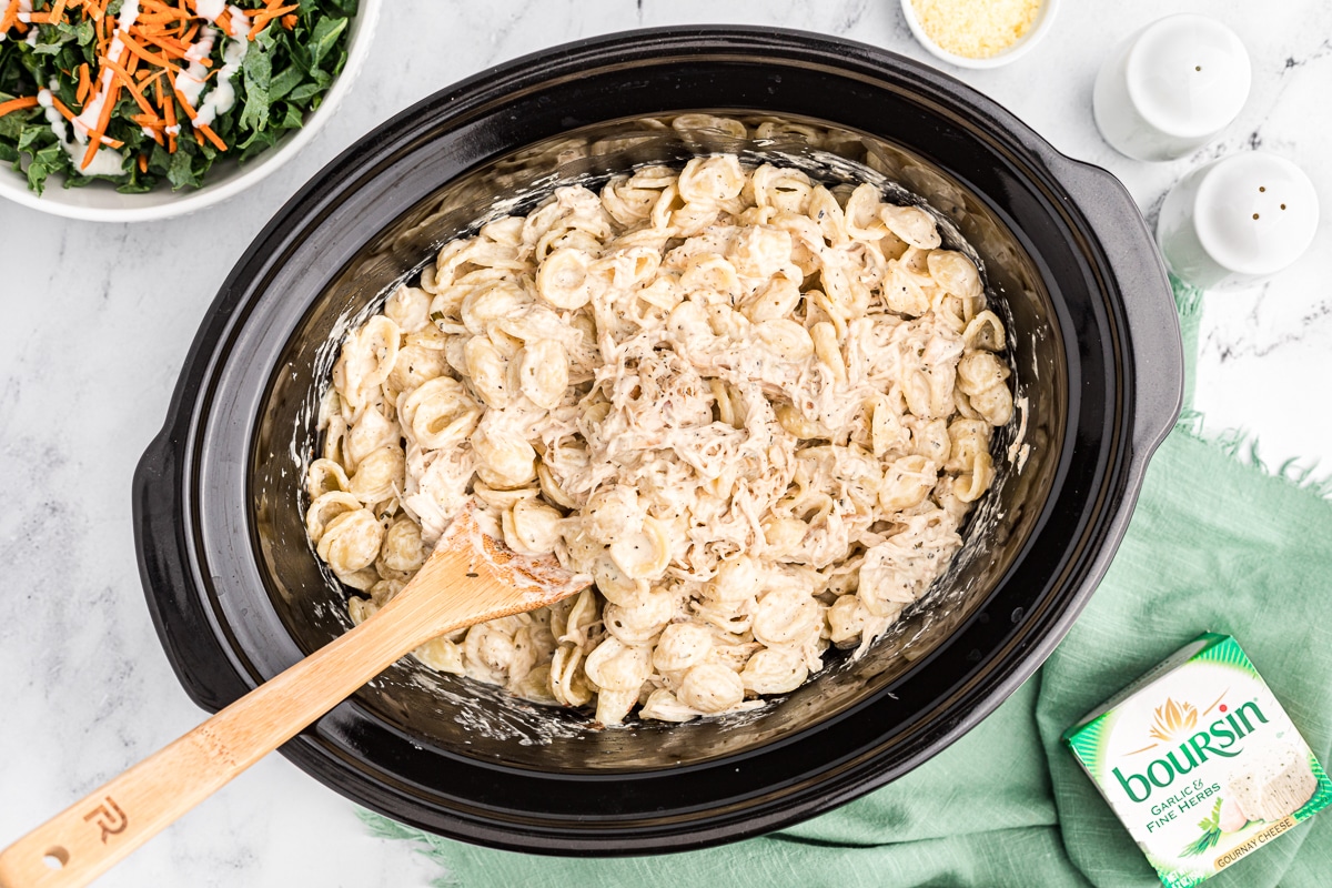 cooked boursin cheese chicken pasta with wooden spoon in it.