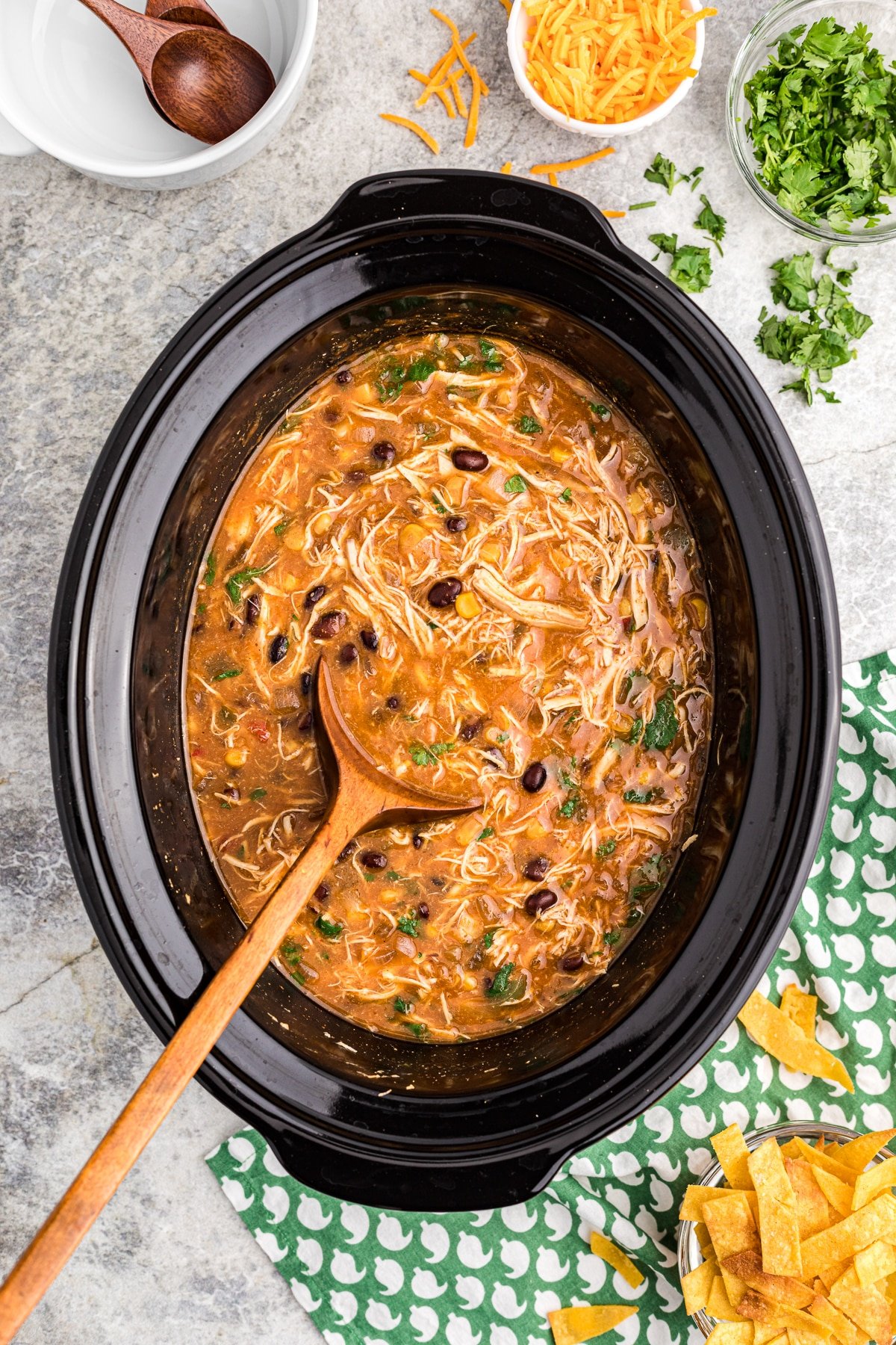 chicken tortilla soup with wooden spoon in it.