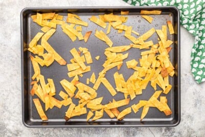 corn tortilla strips on a sheet pan, browned.