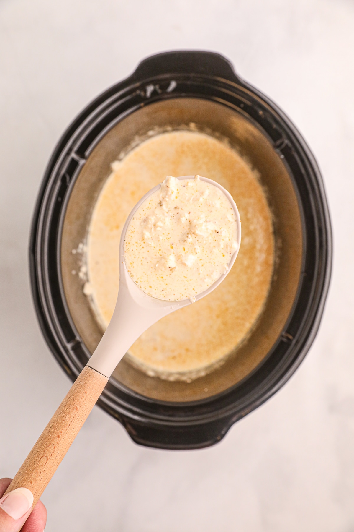 overhead shot of cream of crab soup with soup in ladle.