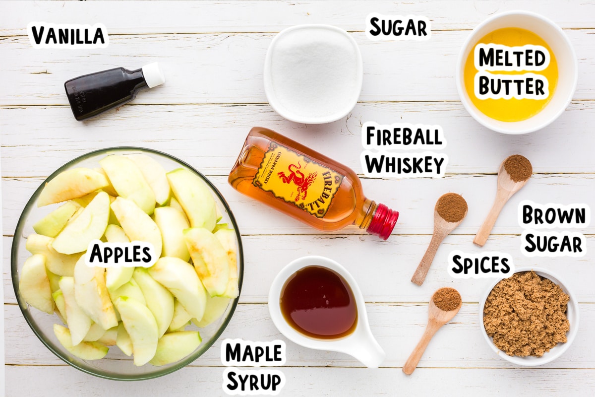 Ingredients for fireball caramel apples on a table with text labels.