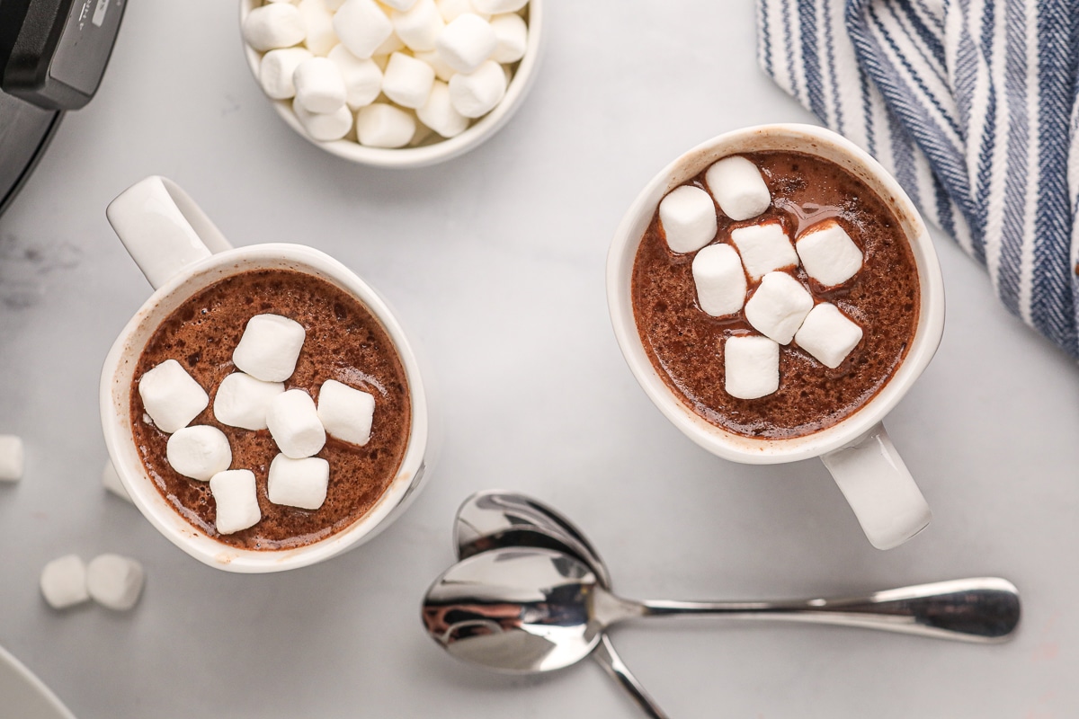 overhead shot of hot chocolate in cups with marshmallows.