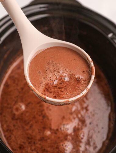 Hot chocolate on a spoon coming from crockpot.