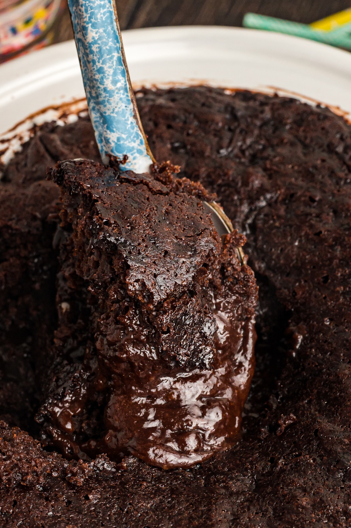 Hot fudge cake on a spoon coming from crockpot.