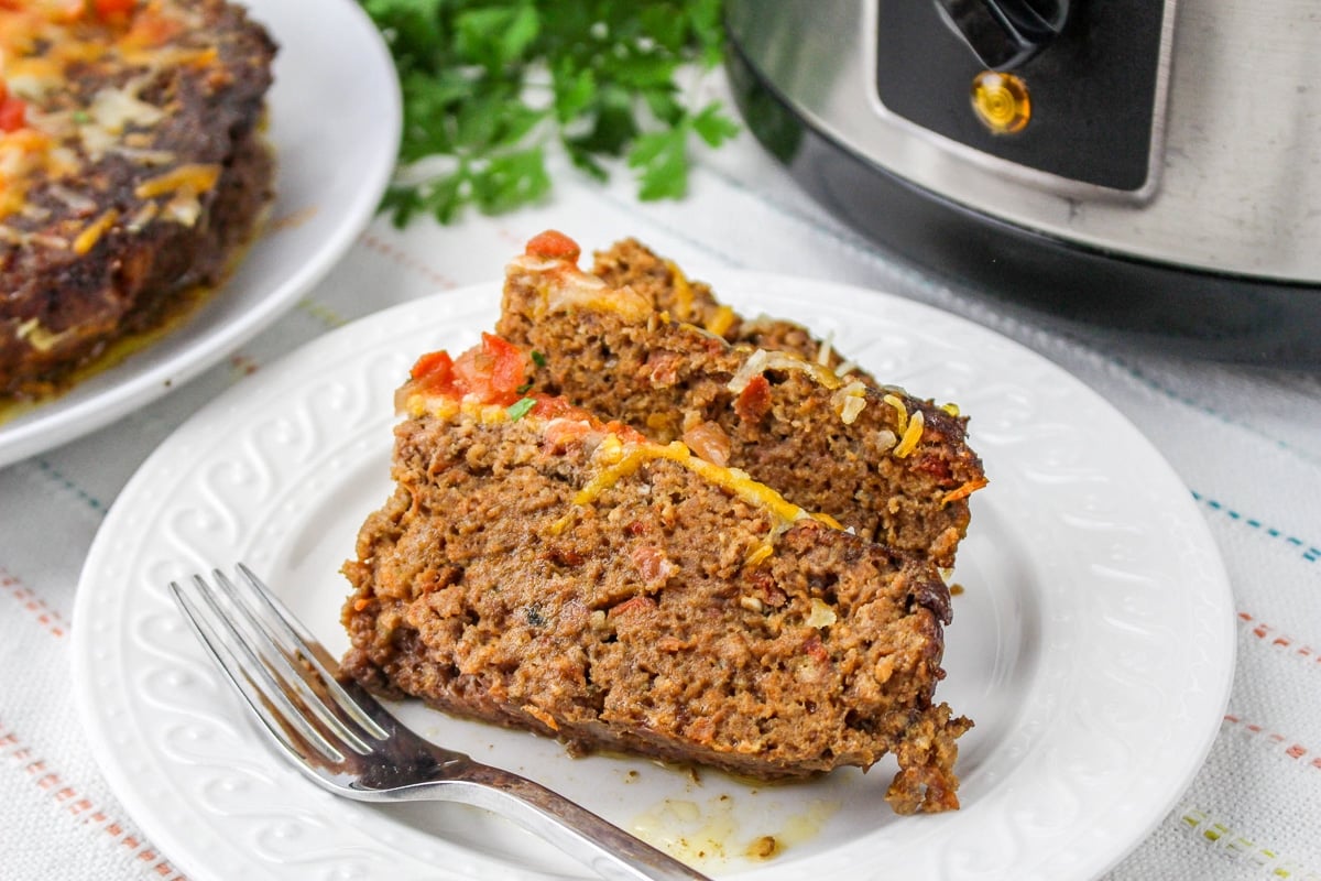 2 slices of meatloaf with cheese and salsa on top.