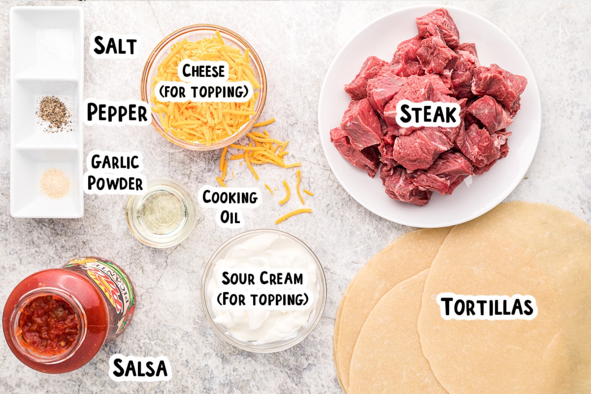 Ingredients for steak burritos on table.