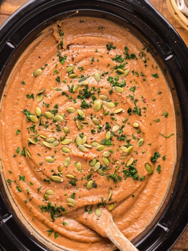 overhead shot of sweet potato soup with pumpkin seeds on top.