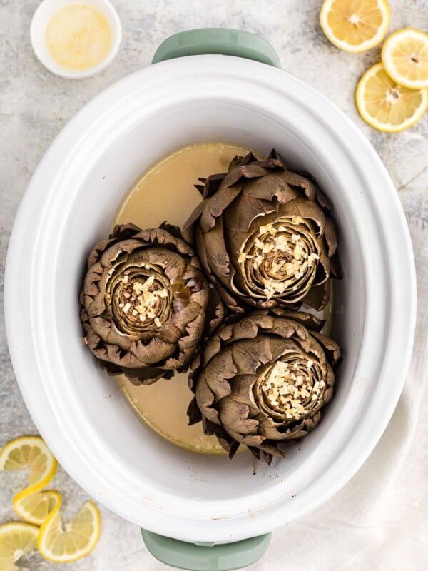 Overhead photo of cooked artichokes in a crockpot.