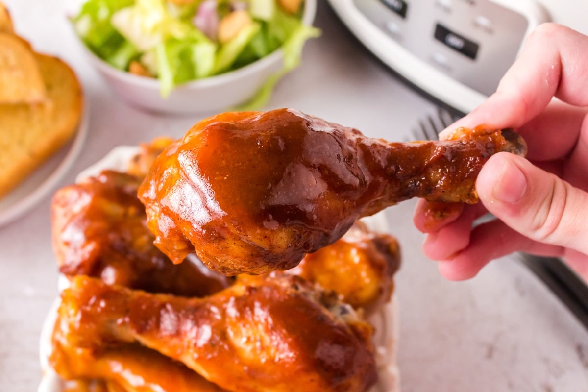 bbq drumstick being held in hand.