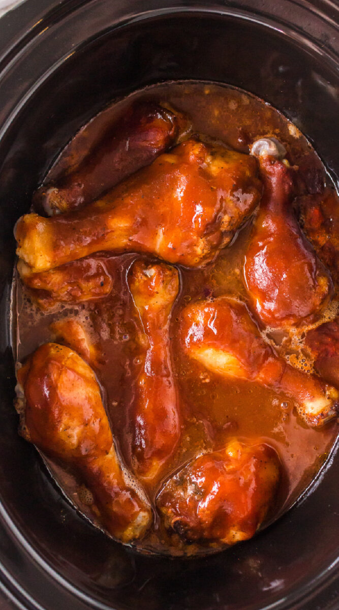 Long image of bbq chicken in slow cooker.