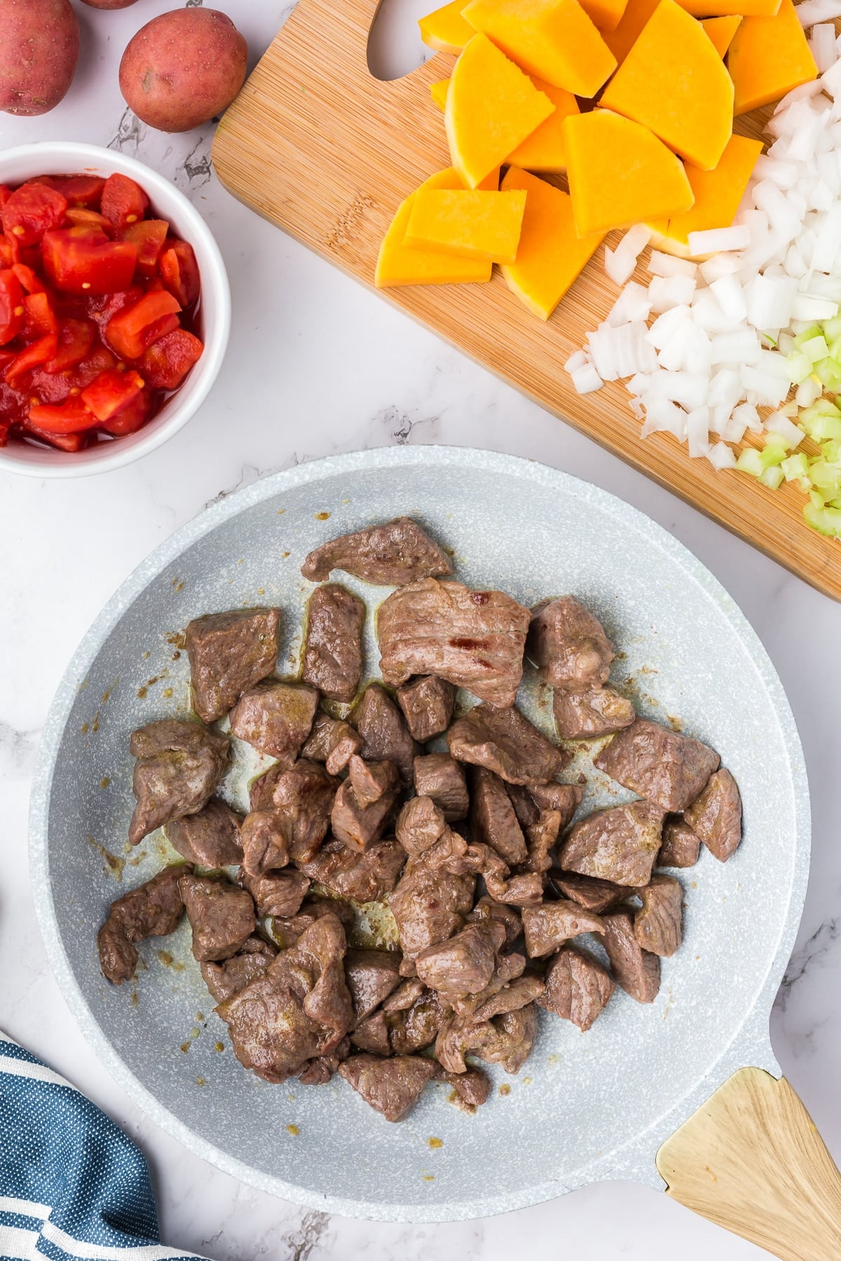 Beef stew meat in a skillet.