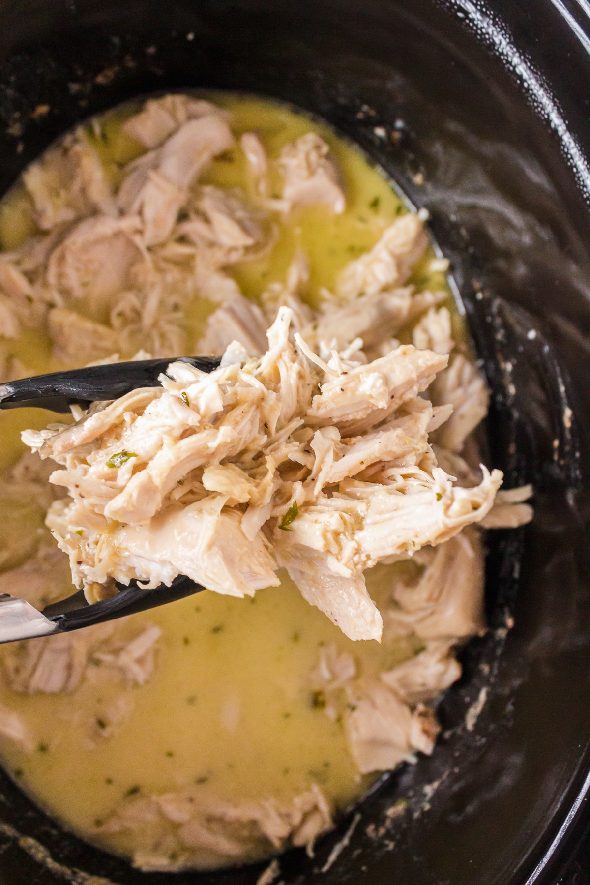 caeser chicken being held by tongs.