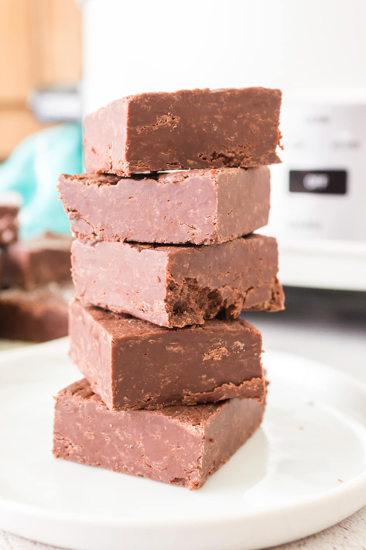 Fudge stacked in front of a slow cooker.