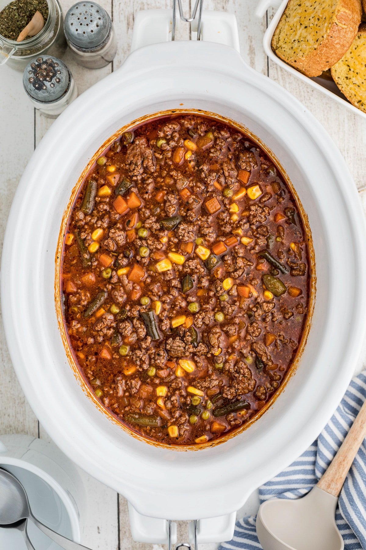 Overhead shot of cooked hamburger soup in crockpot.