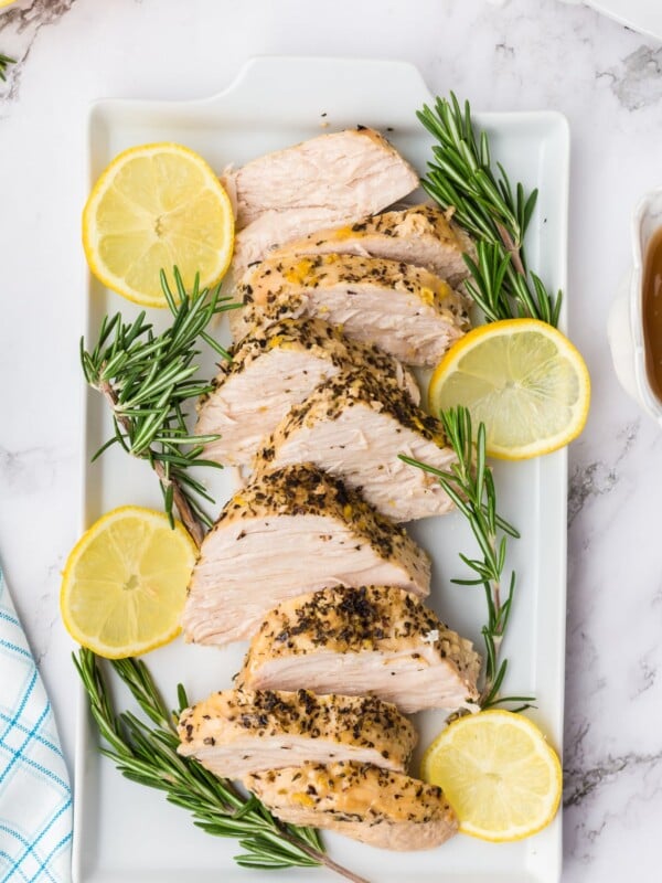 Tray of sliced turkey breast with rosemary and rosemary.