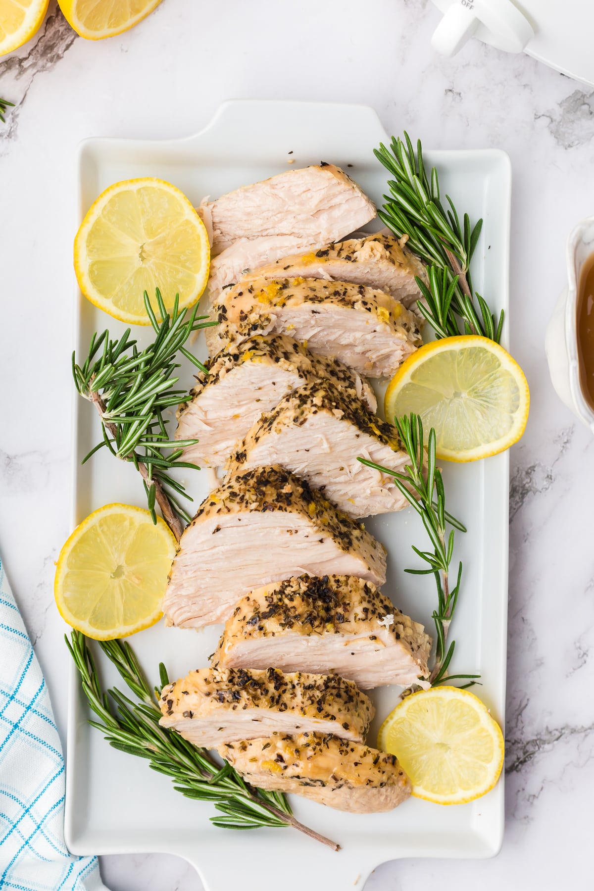 Tray of sliced turkey breast with rosemary and rosemary.