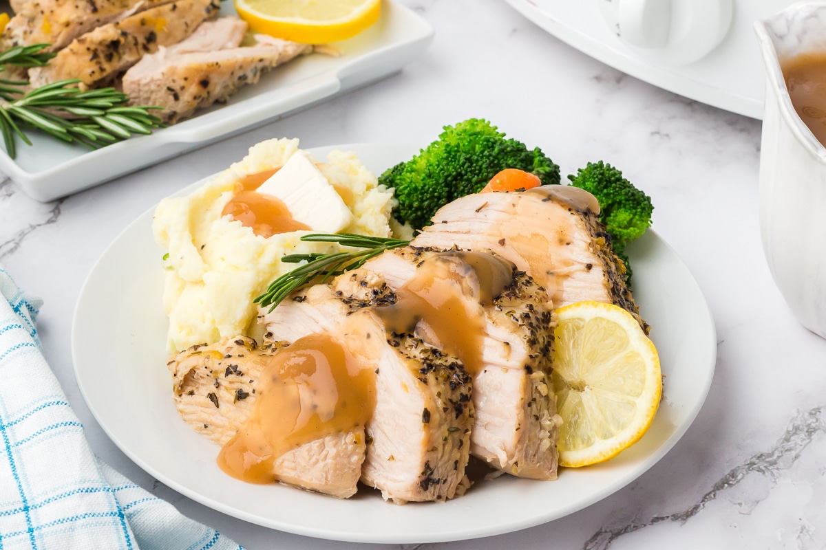 plate of turkey breast with gravy on top.