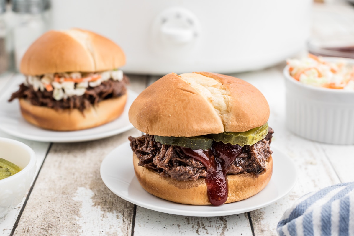 2 plates with venison bbq sandwiches.