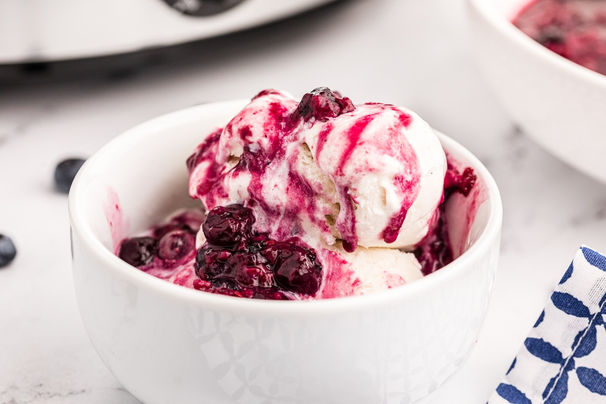 bowl of ice cream with berry compote on top.