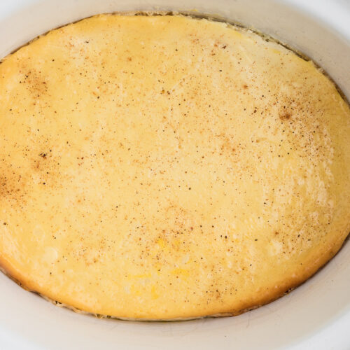 Close up of baked custard in a white crockpot.