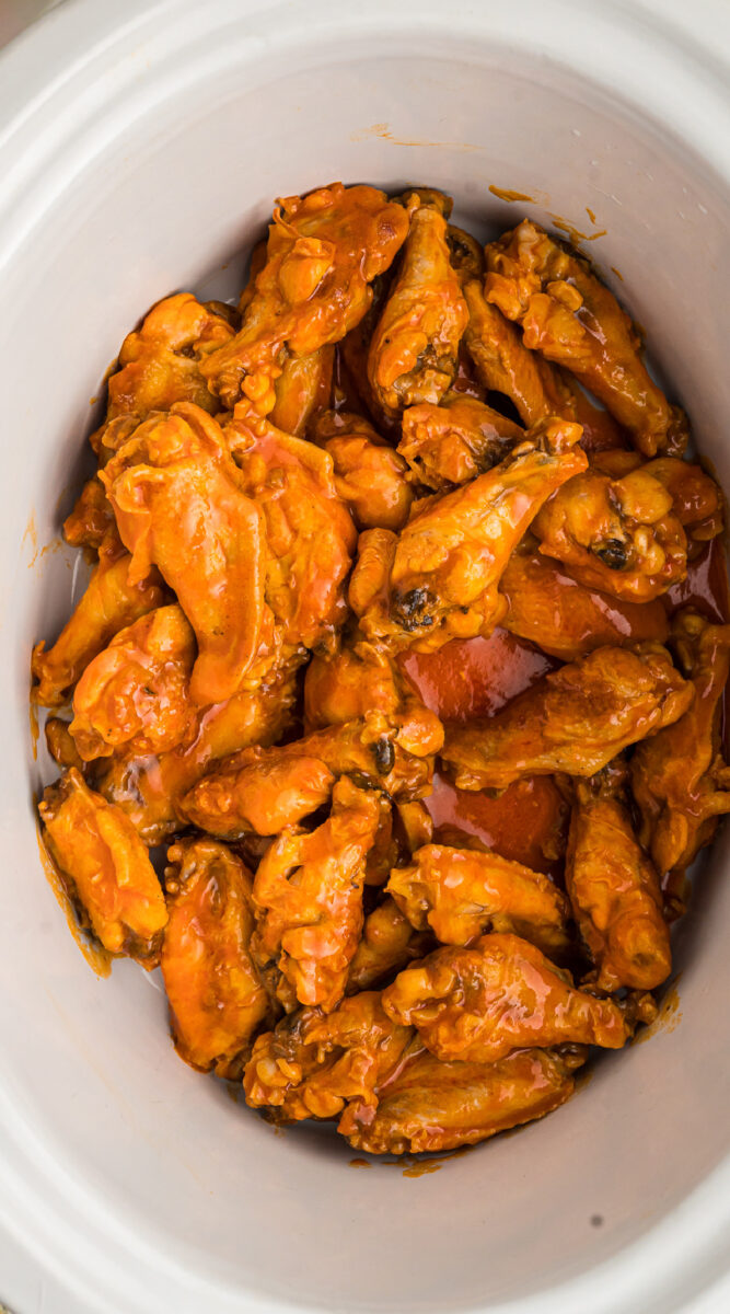 close up of cooked chicken wings in a crockpot.