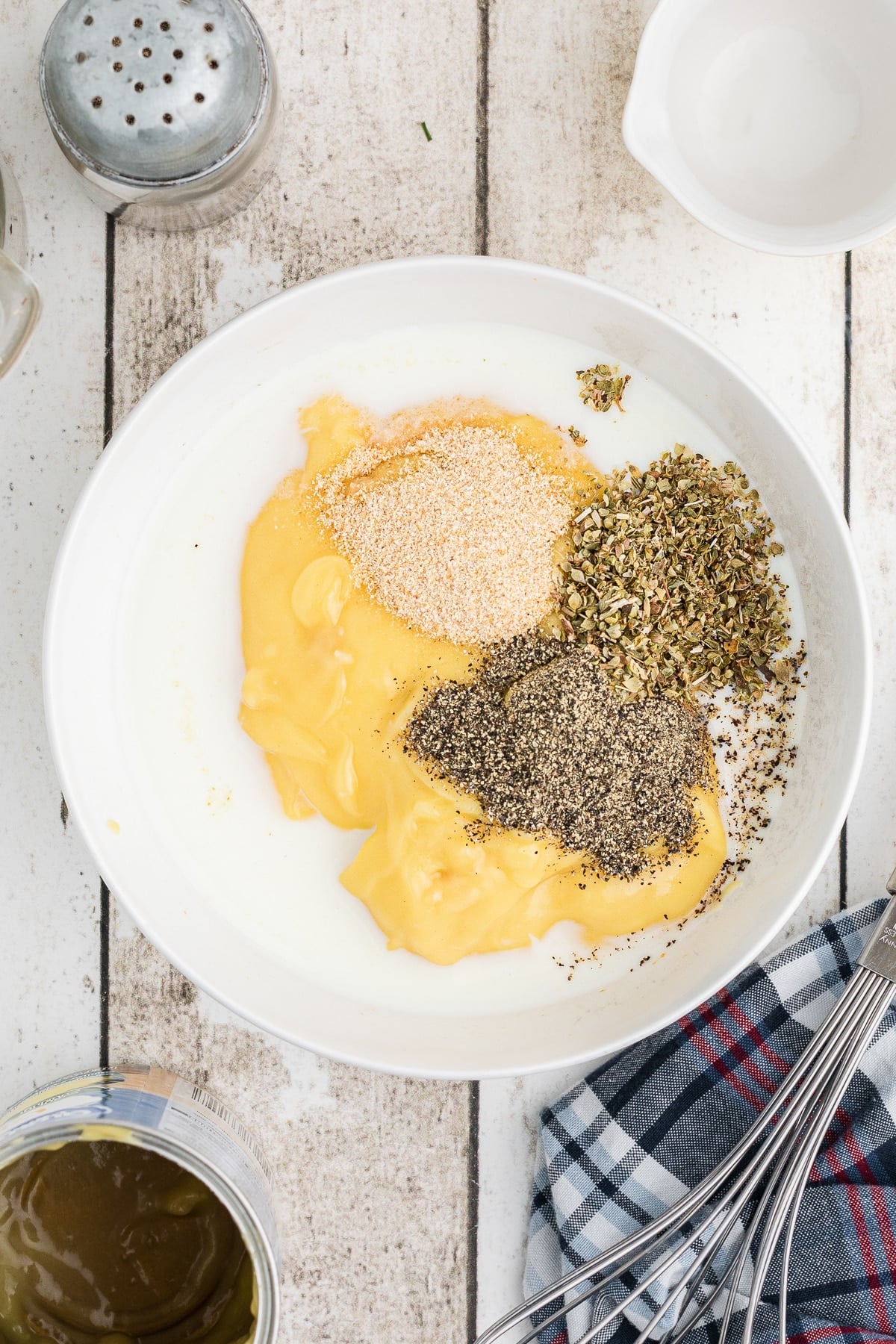 Cream of chicken soup, milk and seasonings in a bowl.