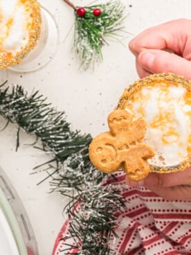 overhead shot of gingerbread lattes with person holding mug.