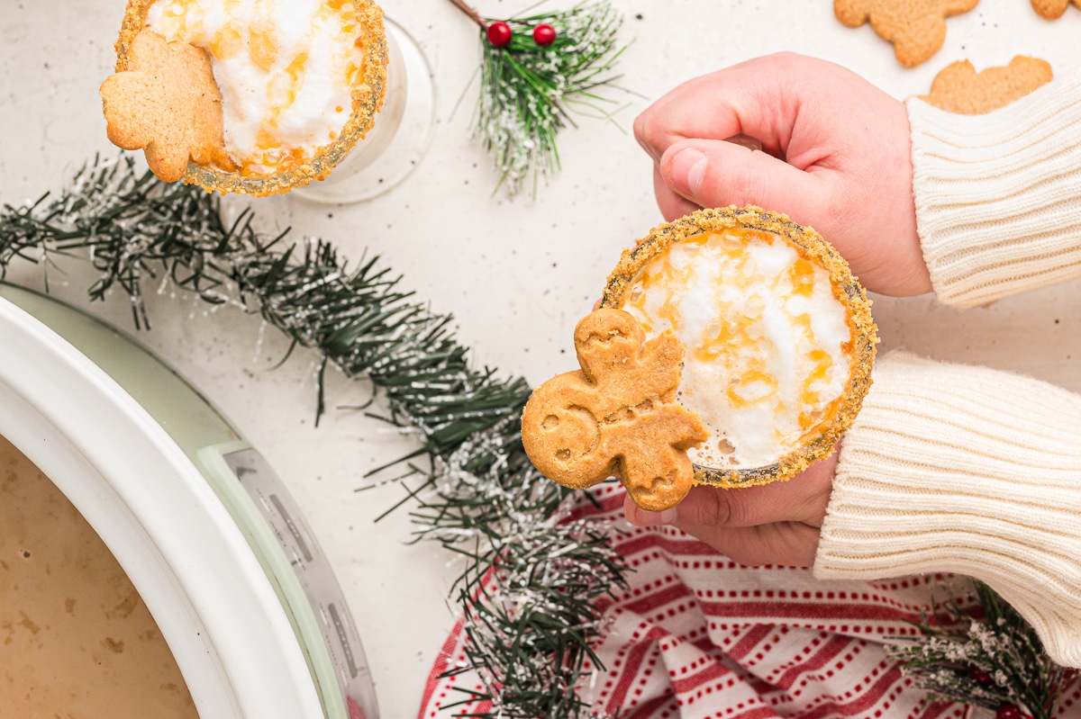 overhead shot of gingerbread lattes with person holding mug.