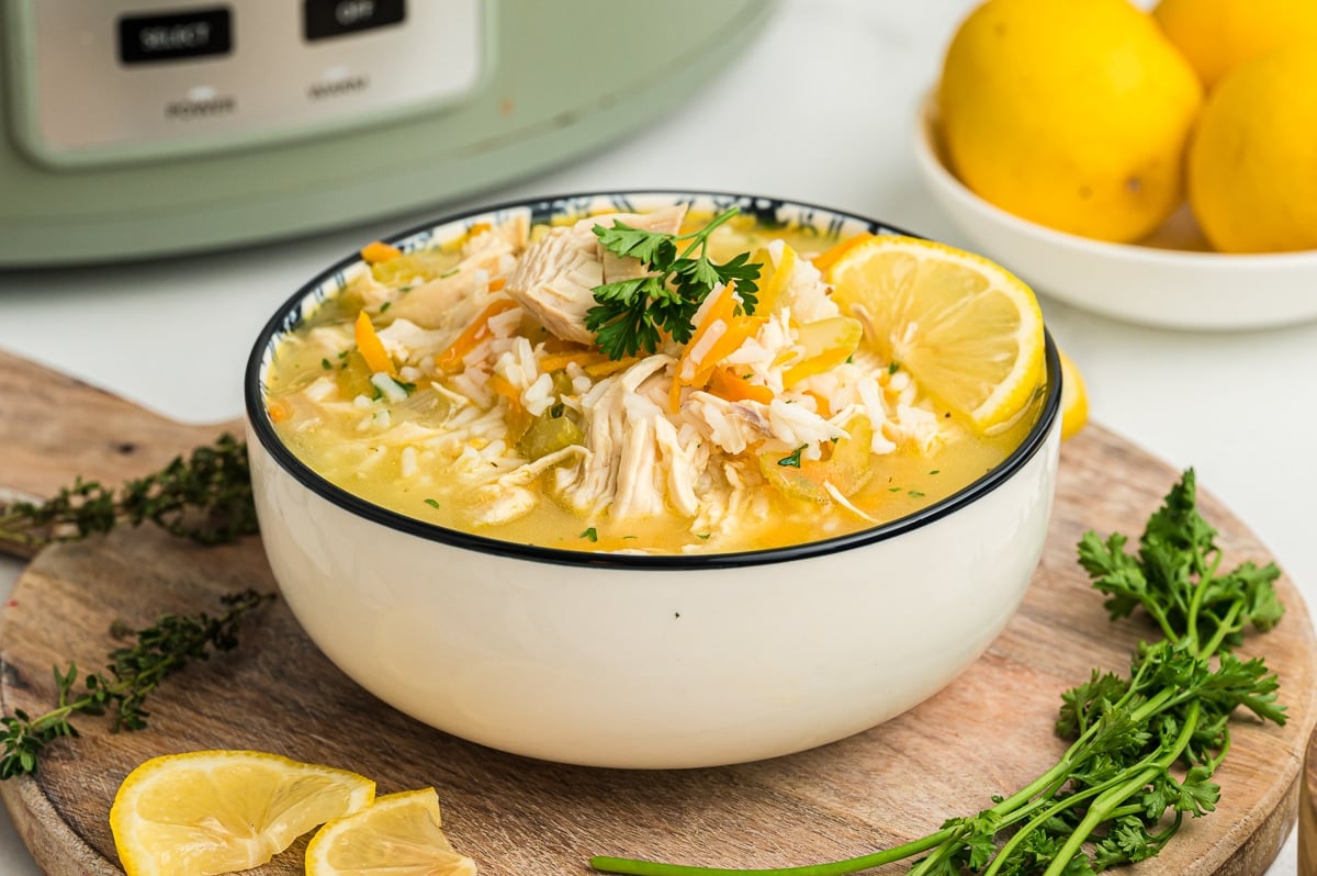 white bowl with lemon chicken and rice soup with parsley.