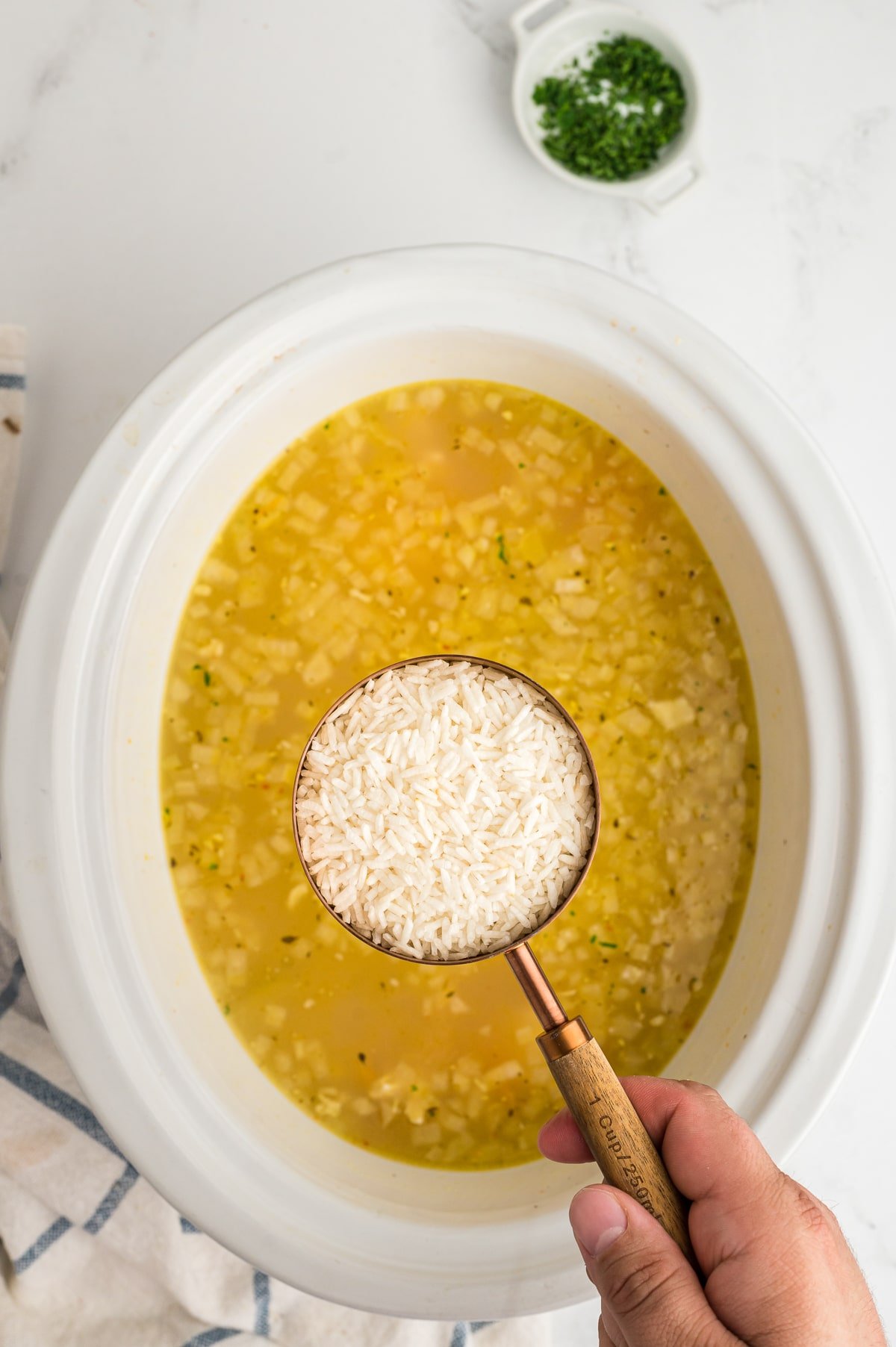 rice being added to the hot lemon chicken soup.