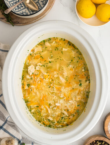 Cooked lemon chicken and rice soup in a slow cooker.