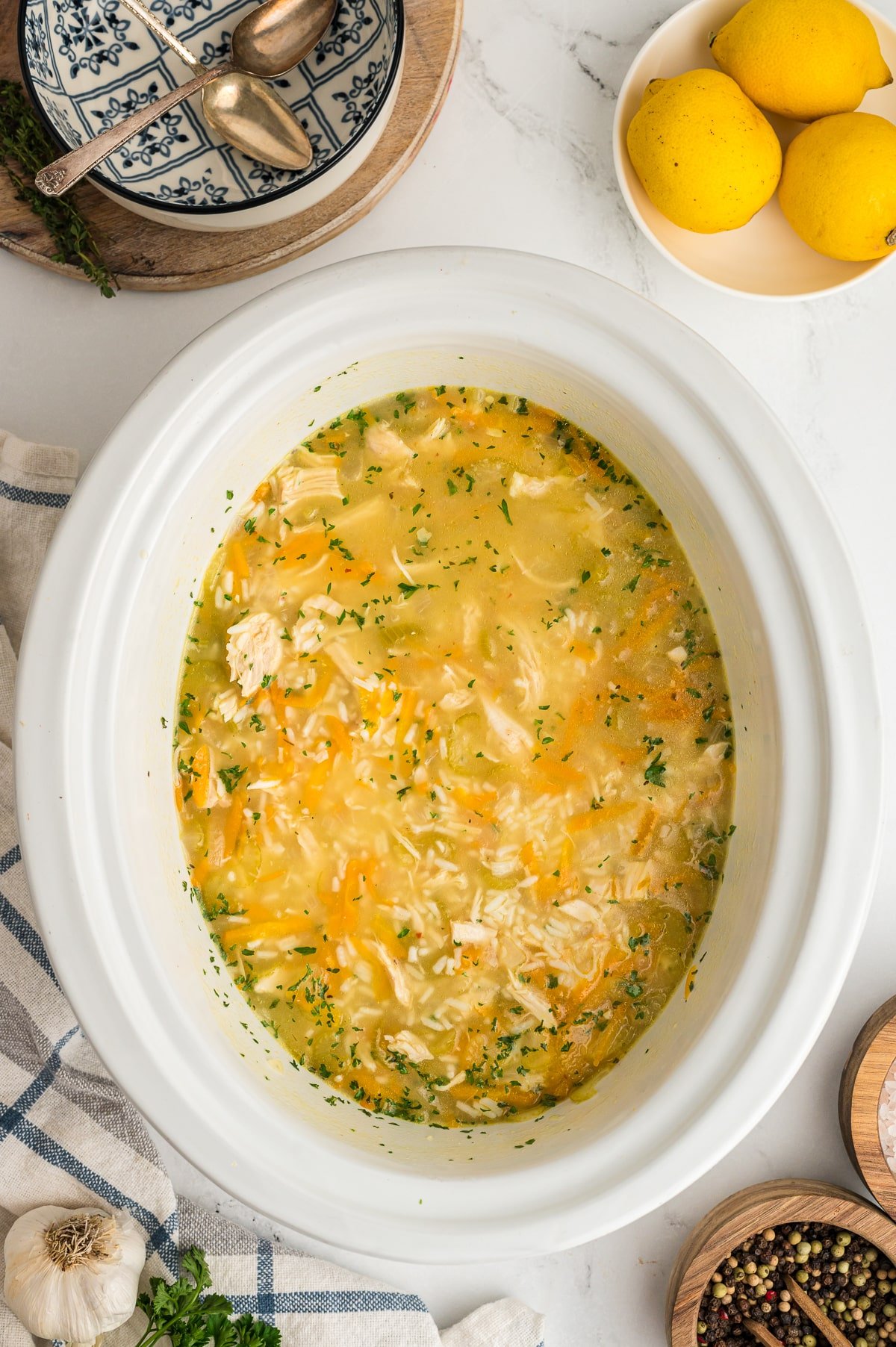 Cooked lemon chicken and rice soup in a slow cooker.