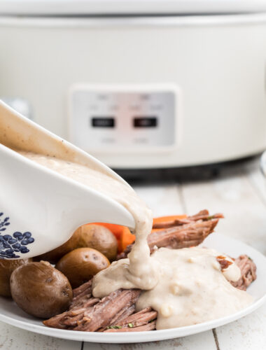 Blue cheese gravy being pour over beef.