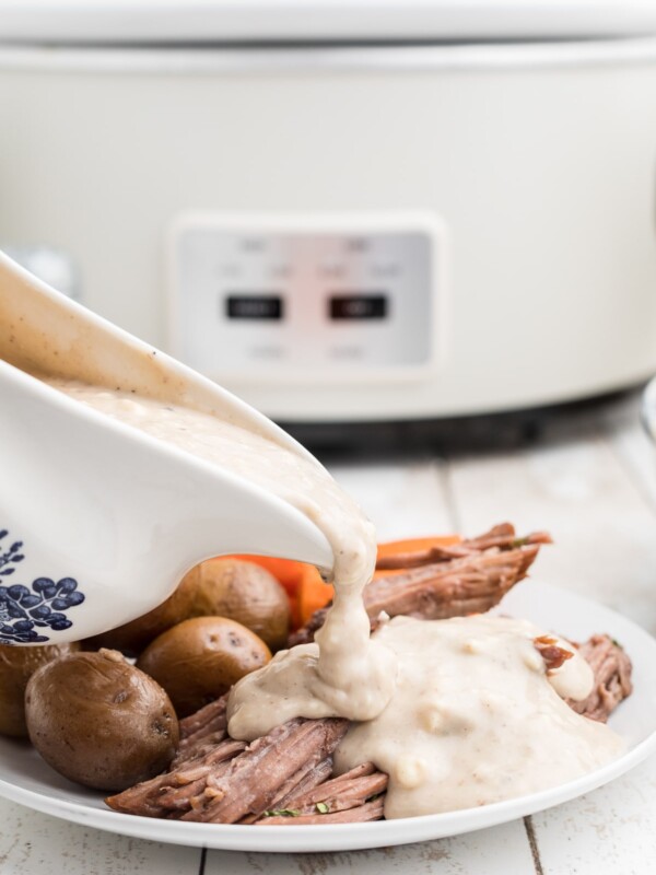 Blue cheese gravy being pour over beef.