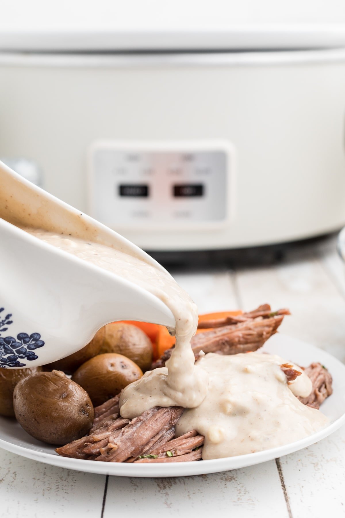 Blue cheese gravy being pour over beef.