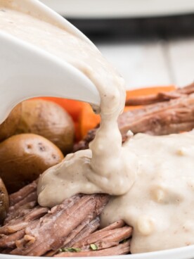 blue cheese being poured over pot roast.