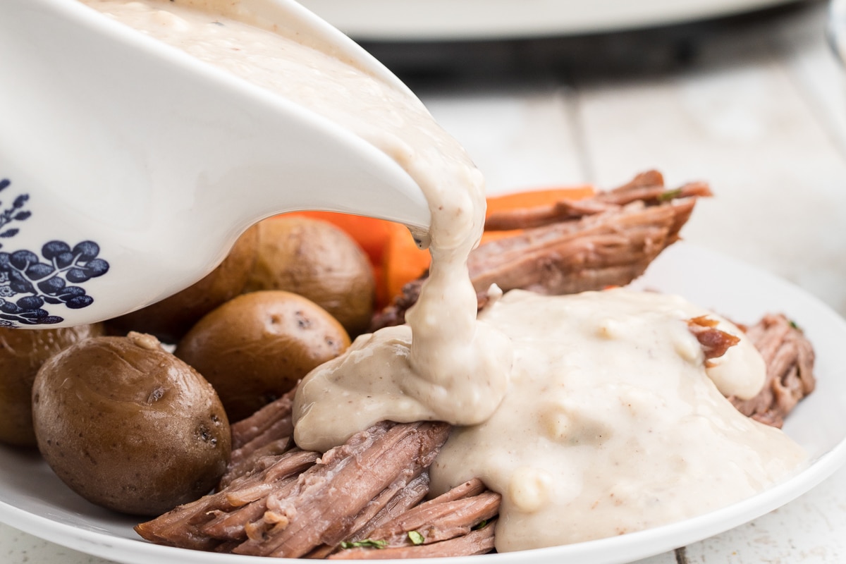 blue cheese being poured over pot roast.