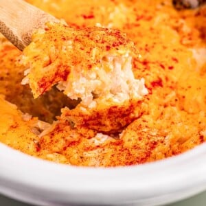 Cooked potatoes romanoff on a spoon.