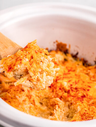 Potatoes romanoff on a spoon with paprika.