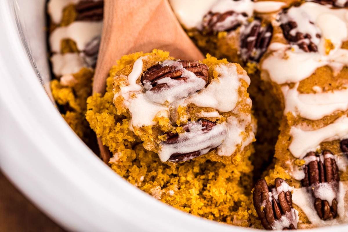 spoon scooping pumpkin cake in slow cooker.