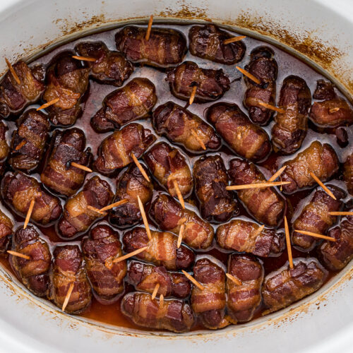 close up of bacon wrapped smokies with toothpicks.