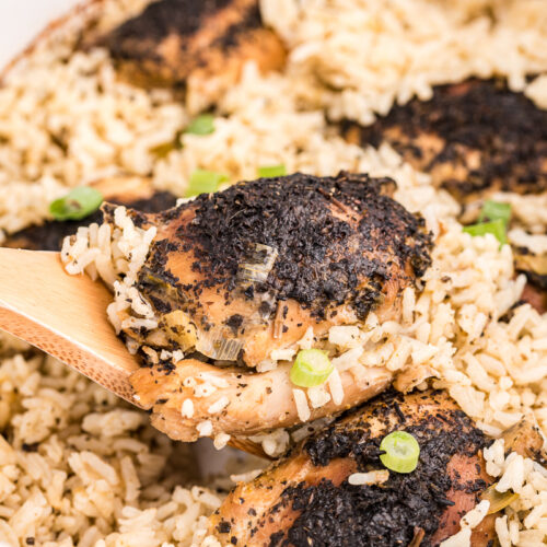 close up of basil chicken and rice on a wooden spoon.