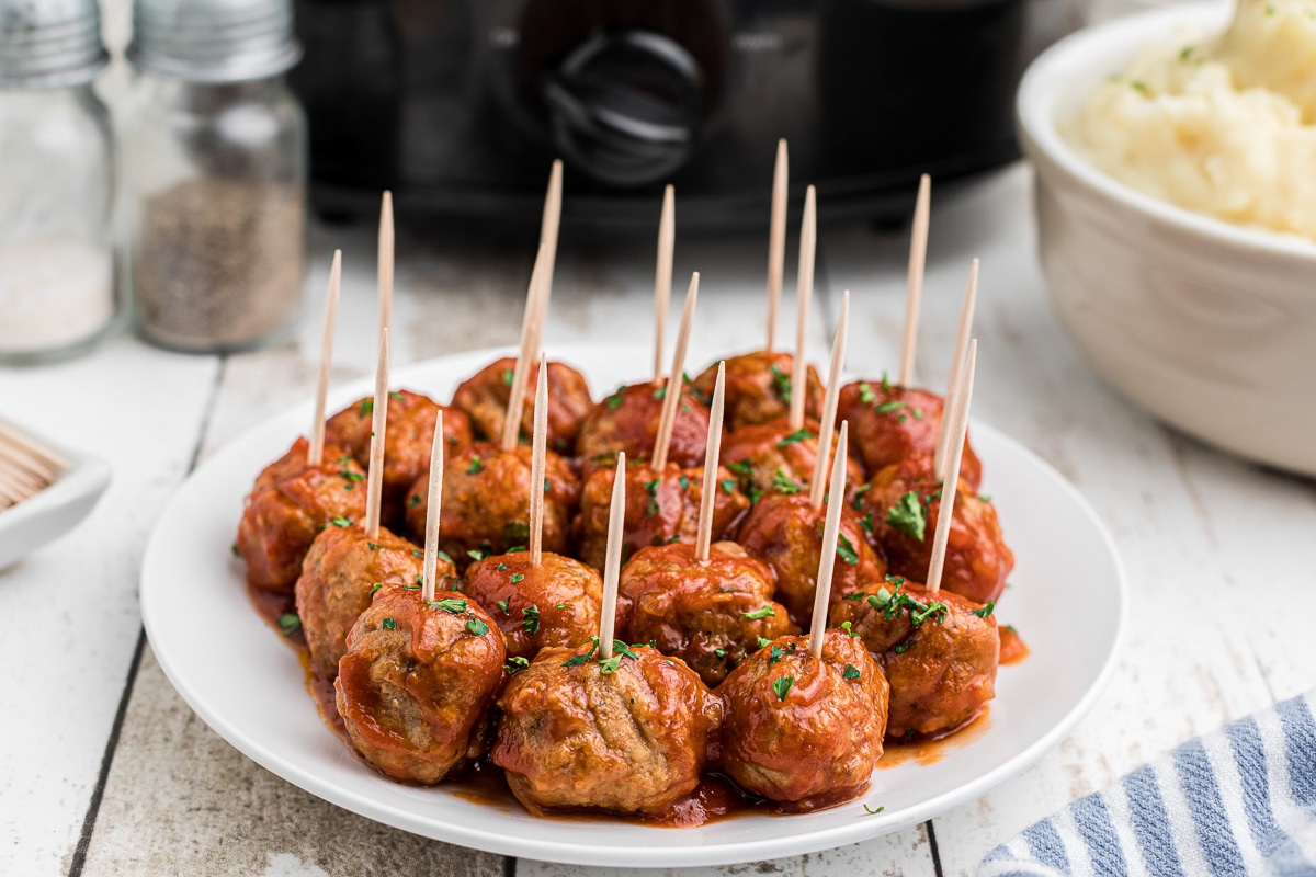 Toothpicks in beer meatballs on a plate.