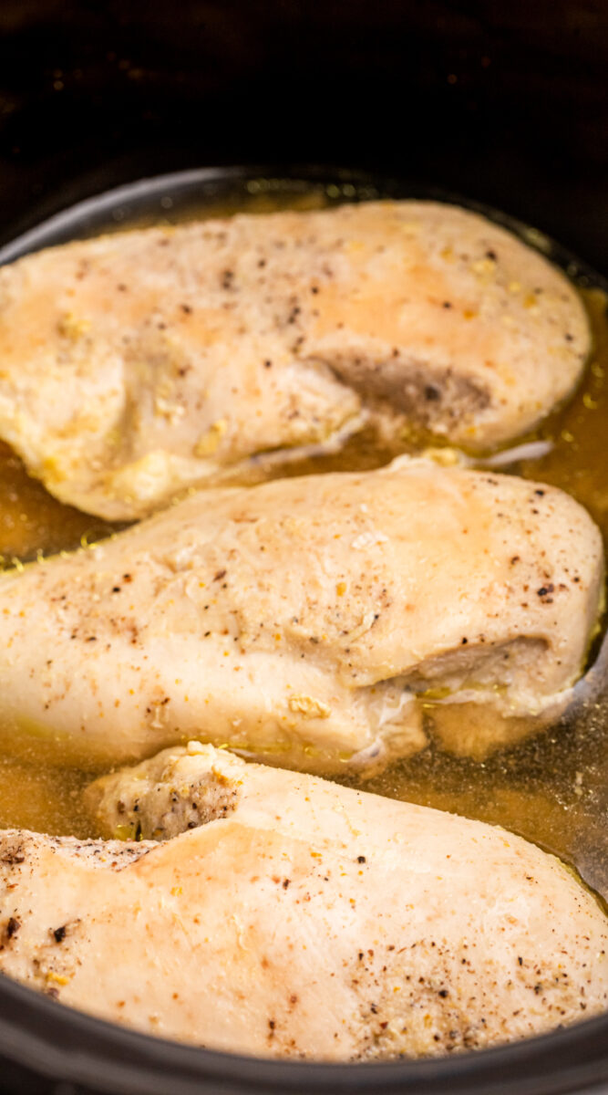 Long image of crockpot chicken breasts.