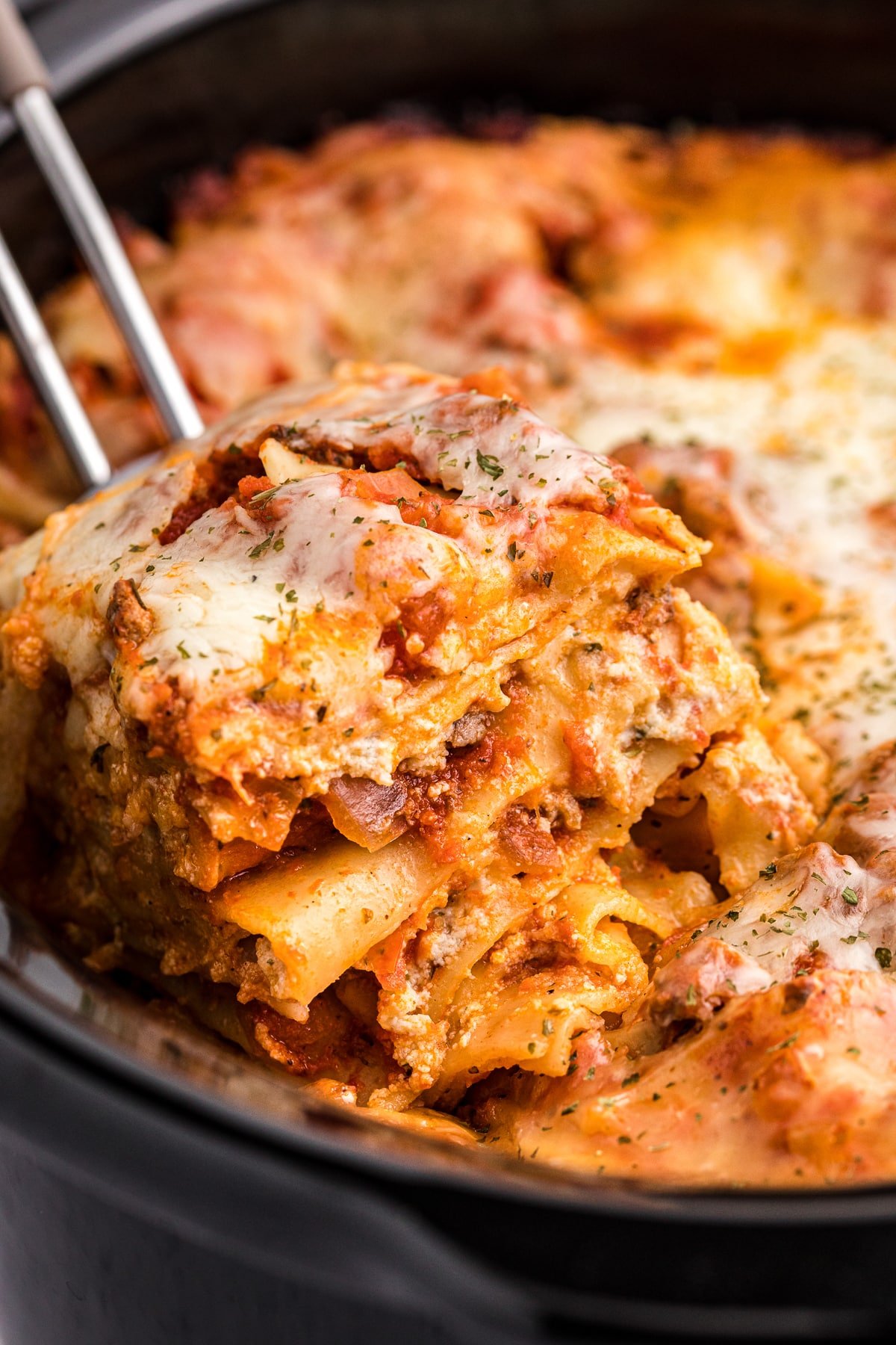 Lasagna on on spatula coming from crockpot.