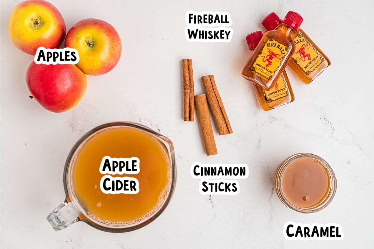 Ingredients for fireball caramel apple cider on a table.