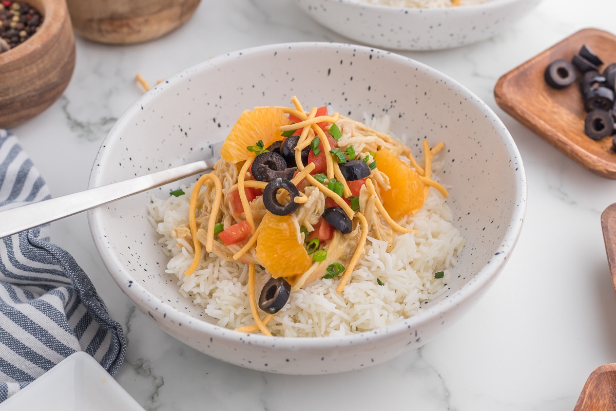 Bowl of rice, chicken and toppings.