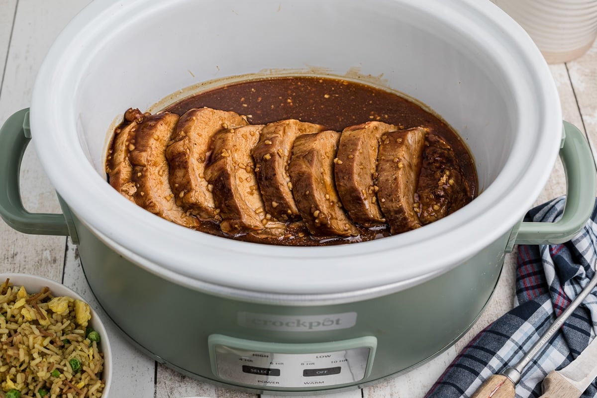 honey garlic pork loin sliced in a crockpot.